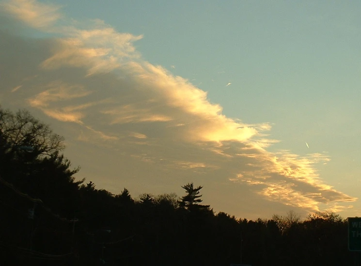 a stop sign is silhouetted against the evening sky