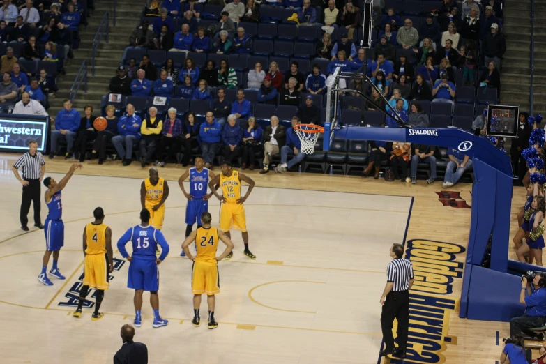 basketball players are on the court and fans watch