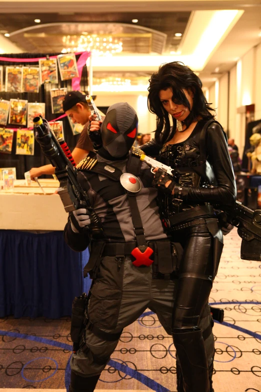 two women with weapons and man in full costumes