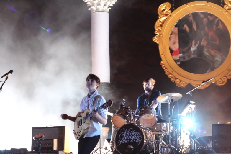 band playing instruments at event, with music and mirror in background