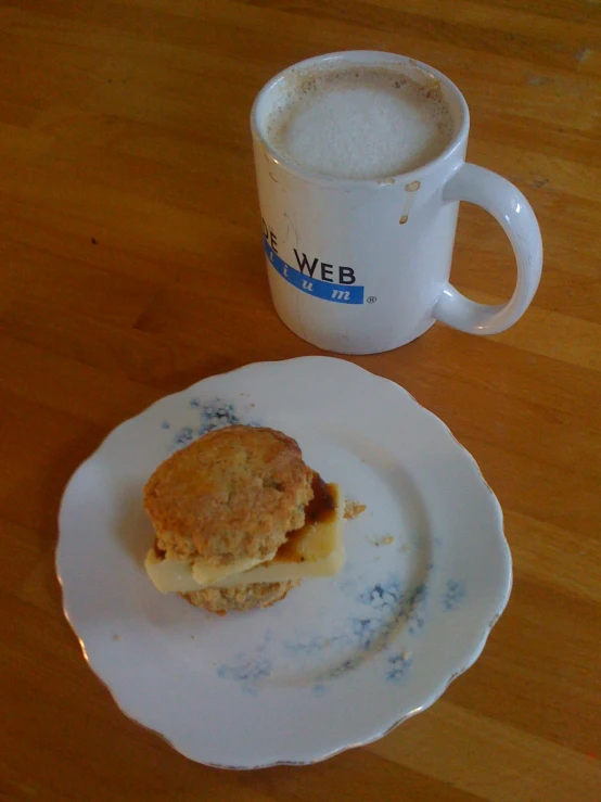 a plate of biscuits sits next to a coffee mug