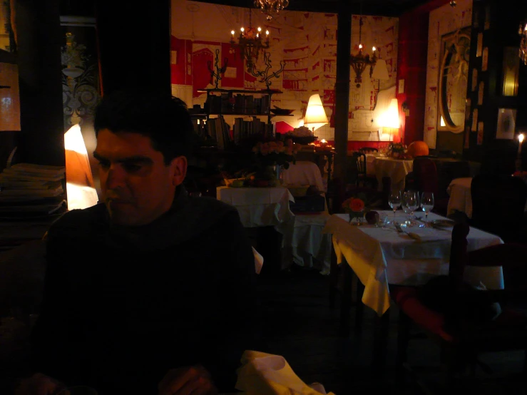 man sitting alone in the dark alone at the dinner table