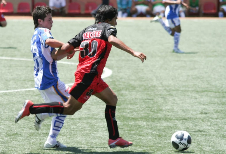 two boys are running with the soccer ball