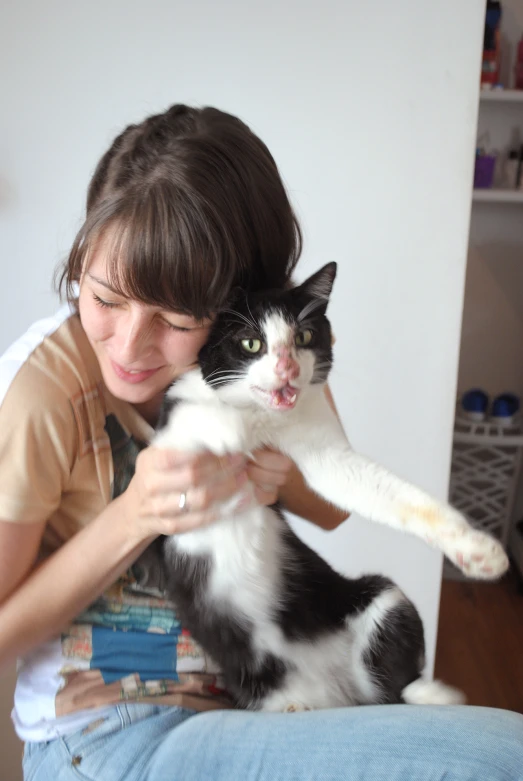 a black and white cat sits on a woman's lap