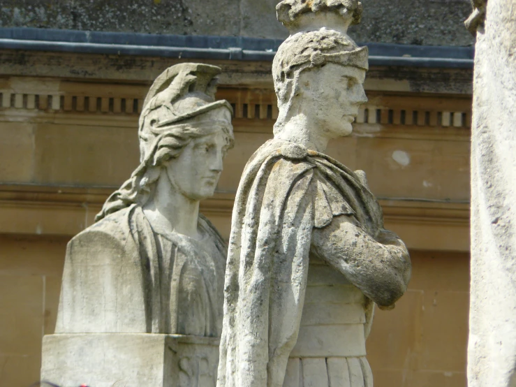 there are two statues of ladies that are in front of a building