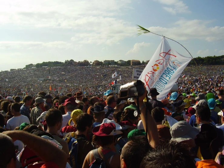 a man holds up a kite while a crowd watches