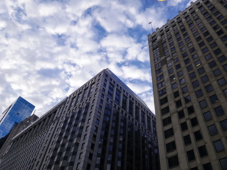 several buildings with clouds and a half moon