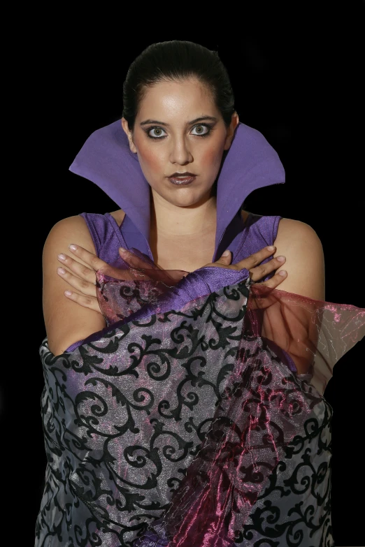 a woman holds a purple and black dress