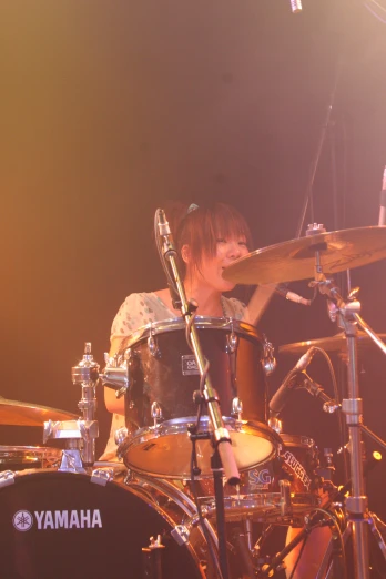 a young man sitting in front of a drumset