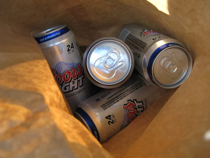 some soda drinks in a small bag next to some coffee