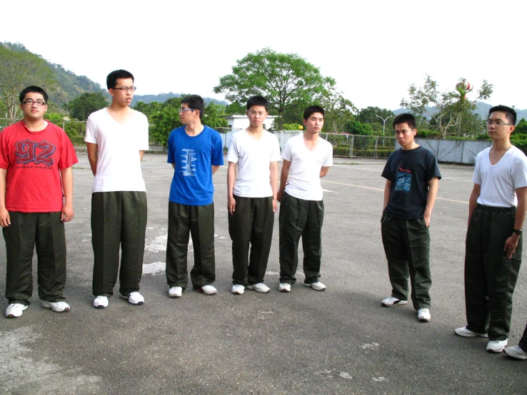 eight young men stand in a parking lot