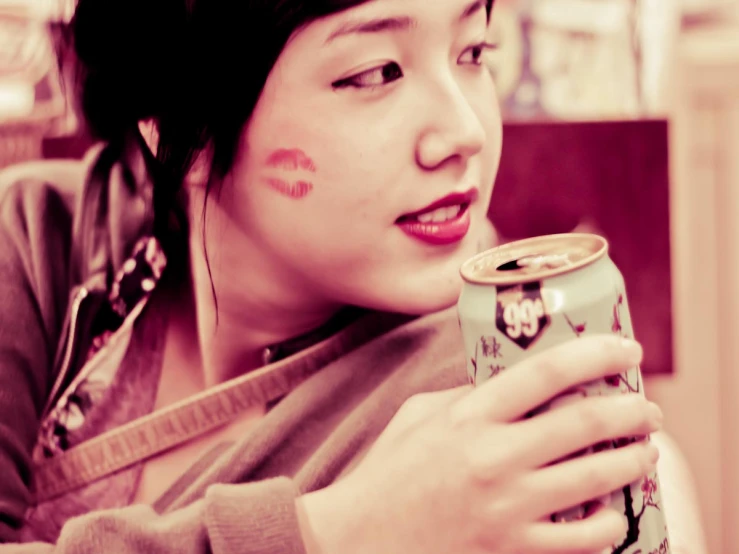 a woman in a gray sweater holds a can of food