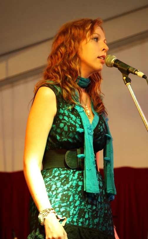 woman with red hair speaking into a microphone