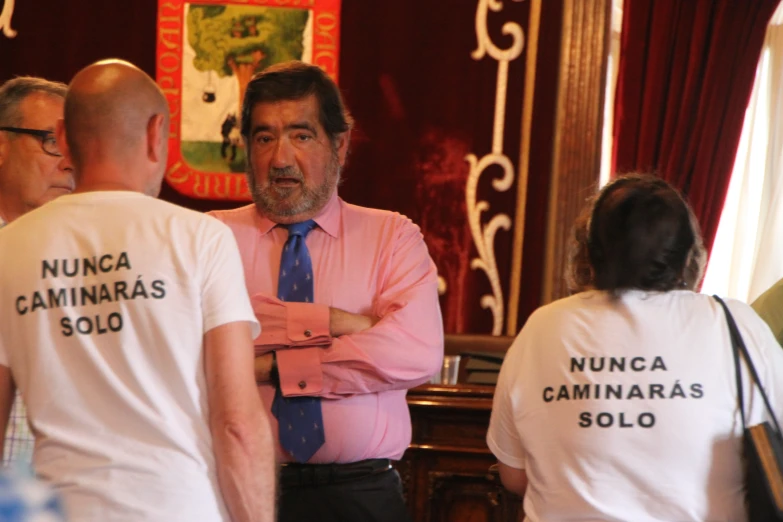 four people stand in front of a mirror and wear t - shirts