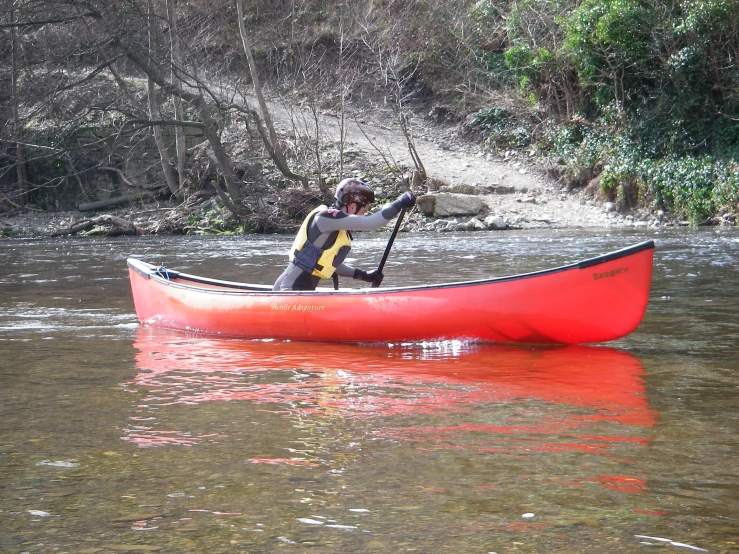 the man is in his canoe on the river