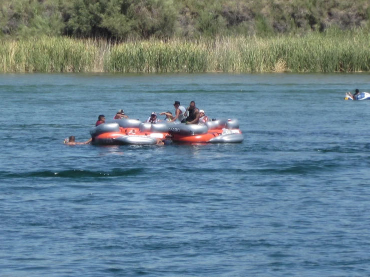 a raft with people and life vests floating in a lake