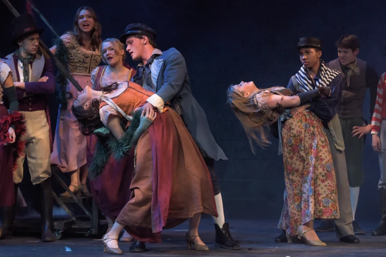 a male dancer is dancing with a group of people in the background