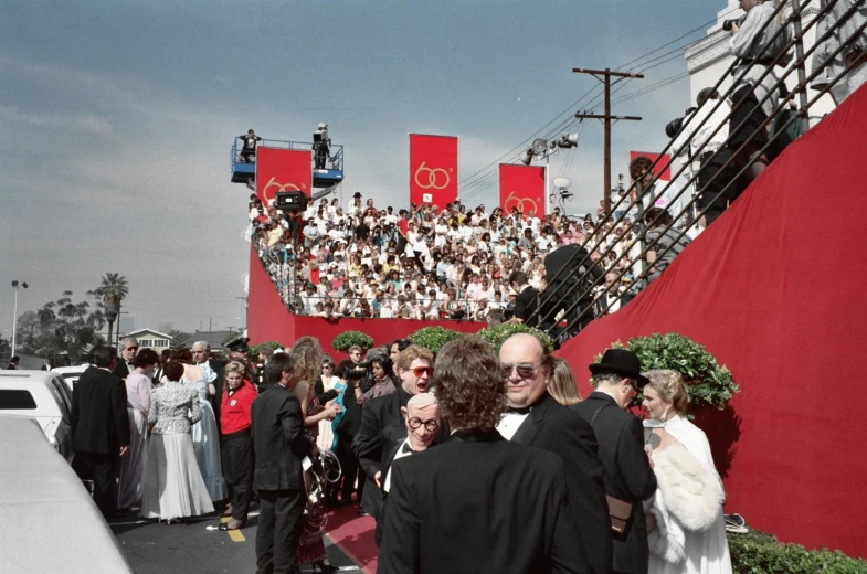 a bunch of people are gathered near a large red wall