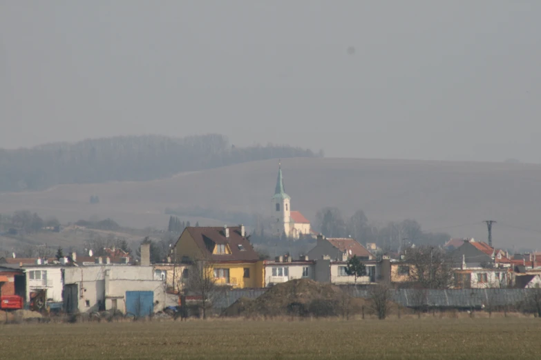 city buildings on a hill with hills in the background