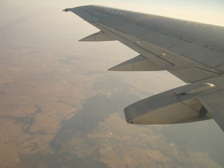 the wing of an airplane looking over the land below