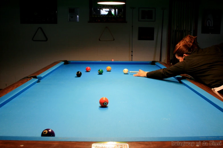 a man is leaning over an pool table
