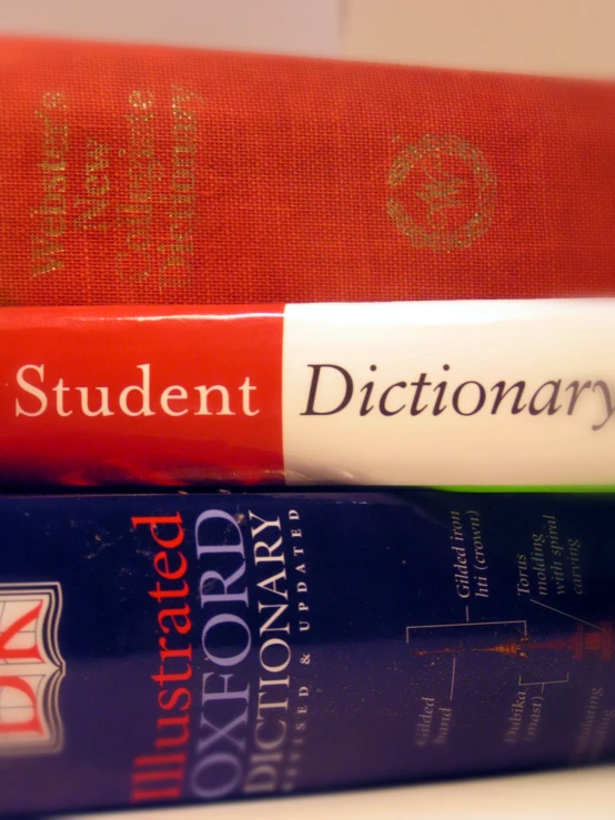 three books on a white counter and one contains a dictionary