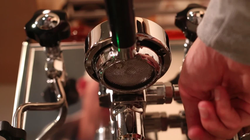 a man touching the faucet to a silver and black sink faucet