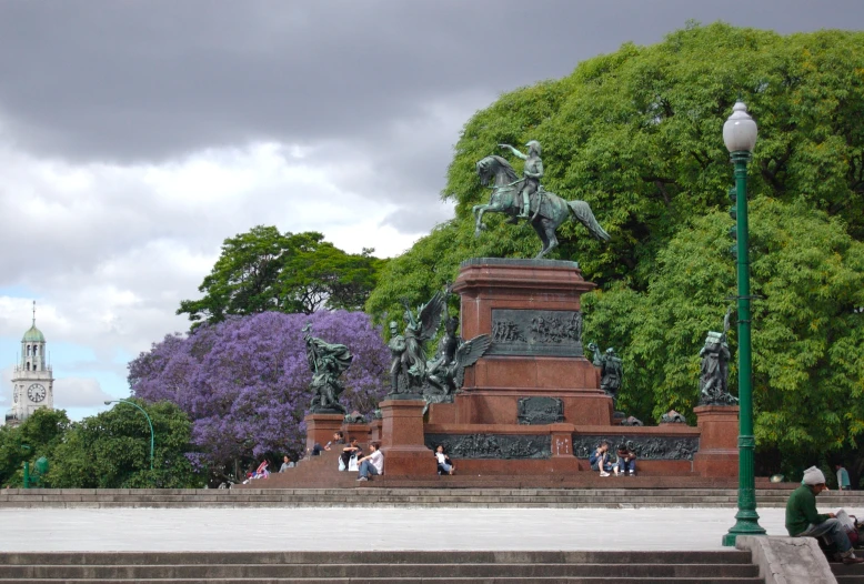 a statue with a horse standing in front of it near trees