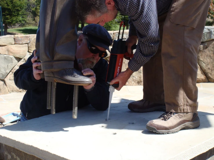 two men look into a pair of shoes