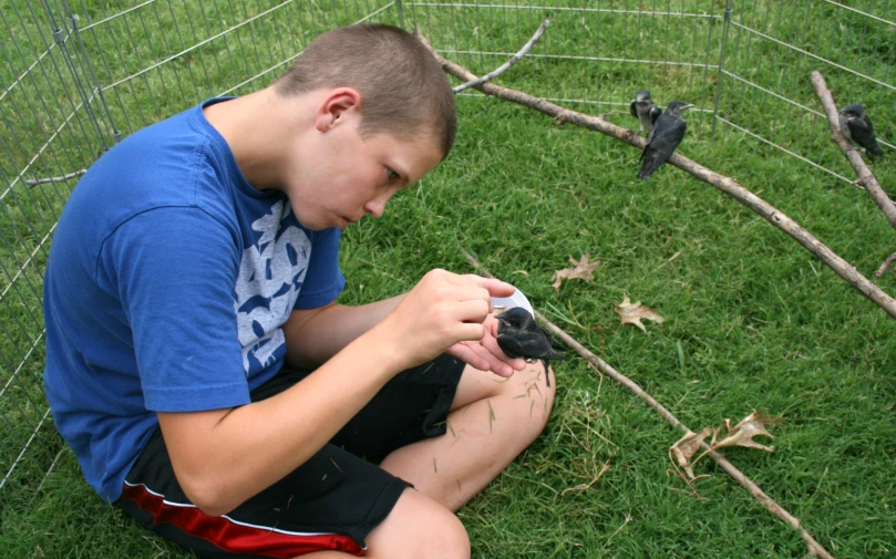 the young man is checking his bird's foot