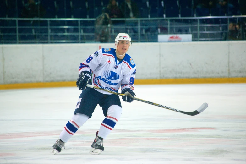 a man skating on a ice rink next to a crowd