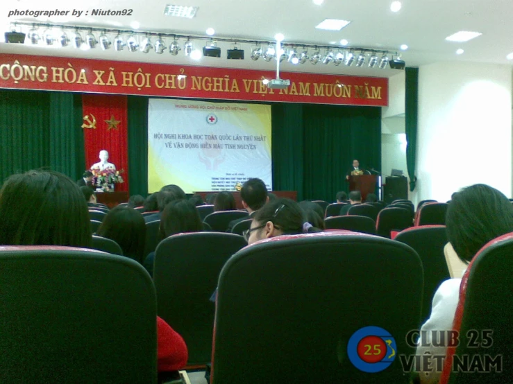 an audience watches a man giving a speech