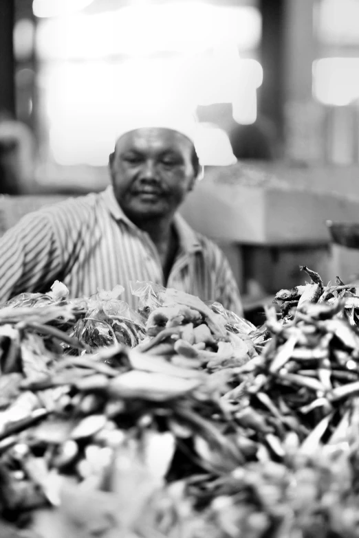 a man sits next to a pile of leaves in a building