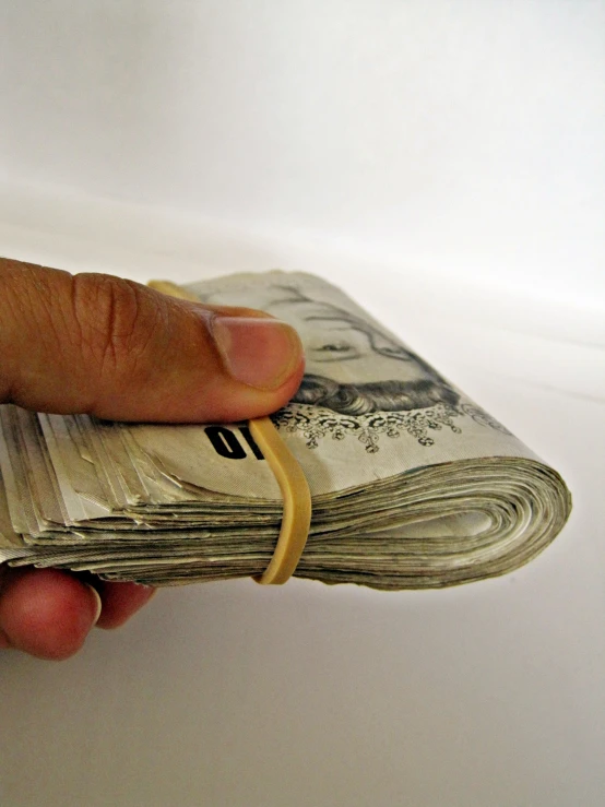 a person holding up a stack of money