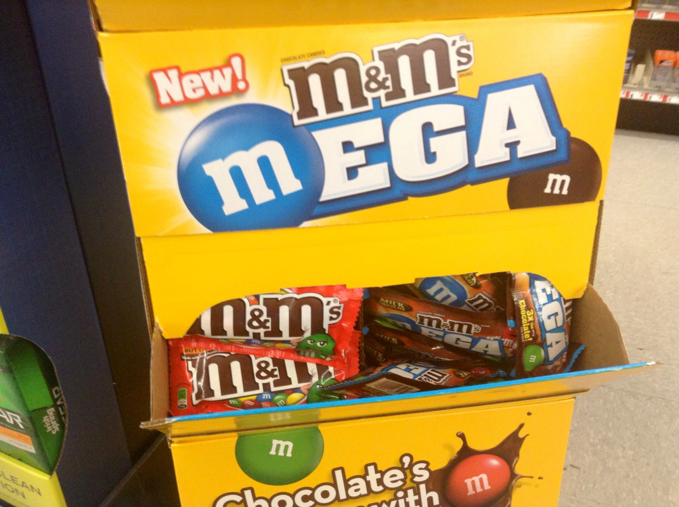 box of m & ms mega chewing candy and a display case of m'n m's chocolate