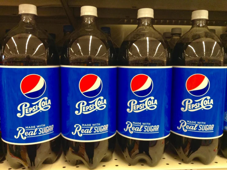 three pepsi cola bottles are on the shelf