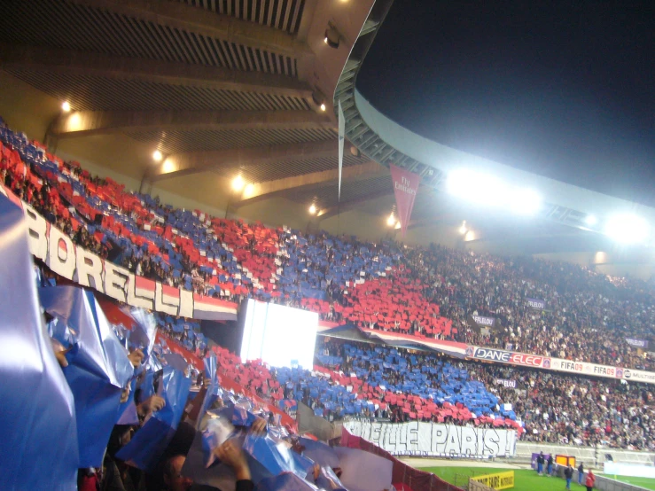 fans are cheering on the stands at a soccer game