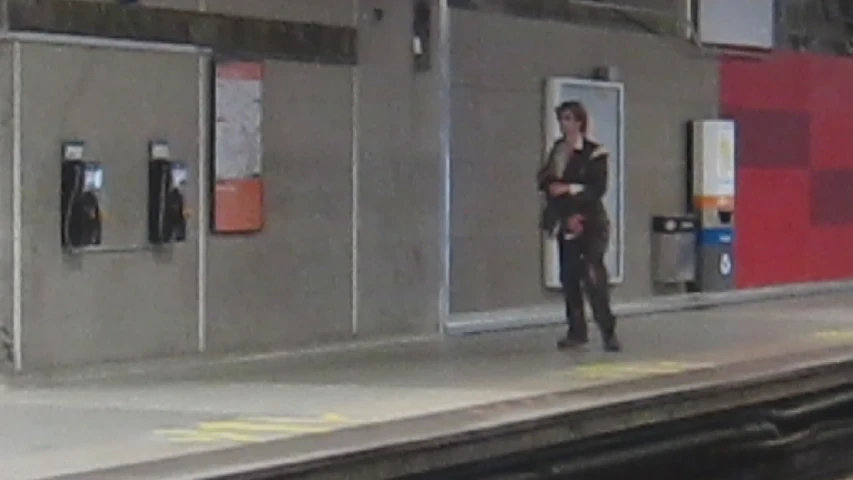 a woman is standing on the train platform