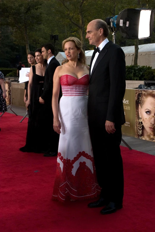 a man and a woman standing on a red carpet