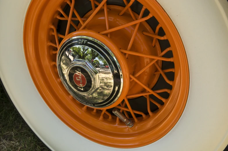 an orange wheel and hubs is on a white vehicle