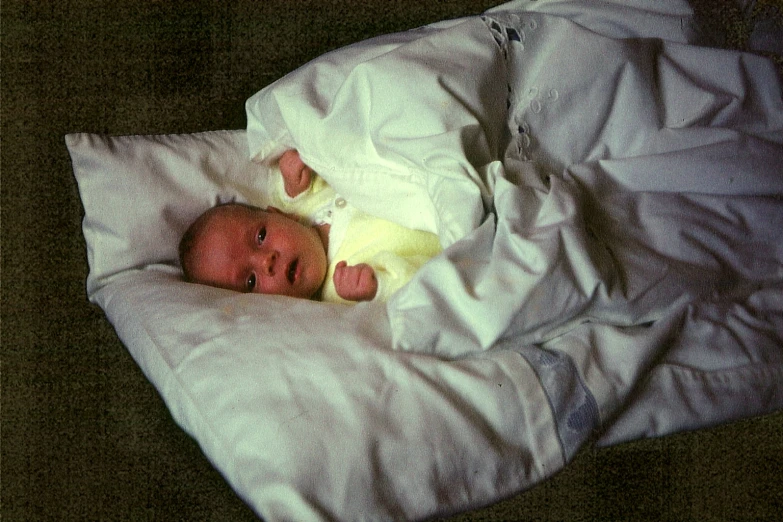 a small baby is laying on a pillow