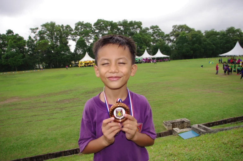 a boy holding two medals around his neck