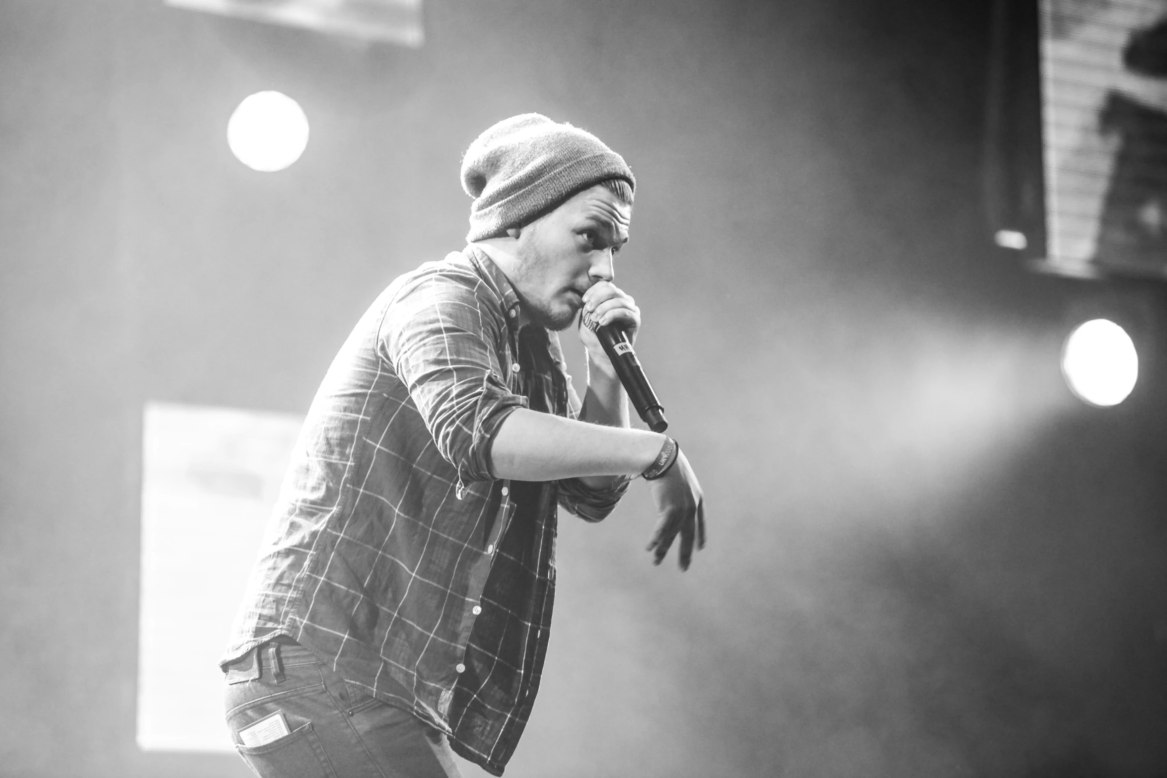 man standing up on a stage singing into a microphone