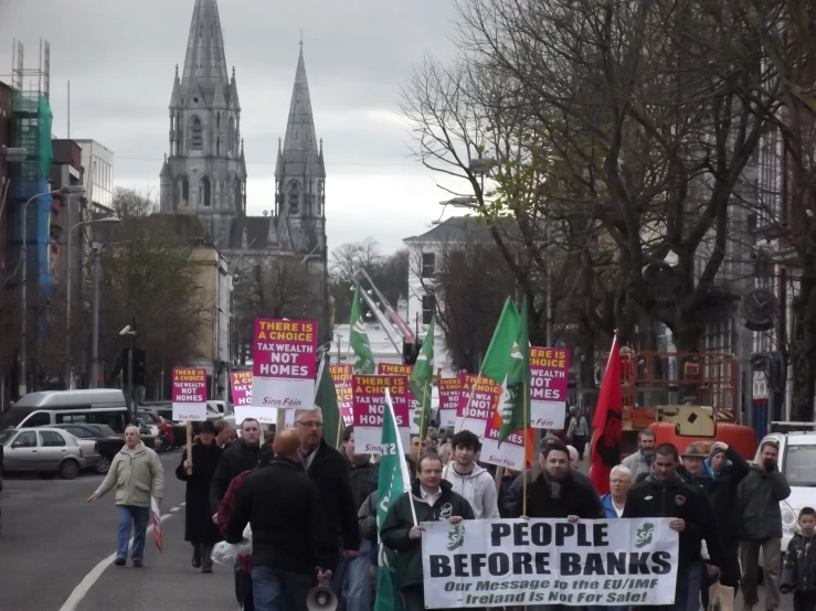 many people holding signs on the side of the street