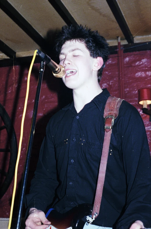 a man that is standing up with a guitar