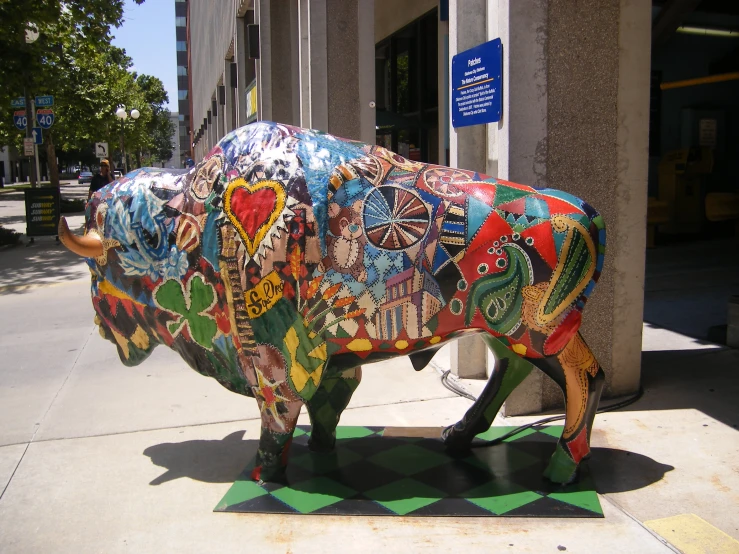 a large bull statue on the sidewalk near a building