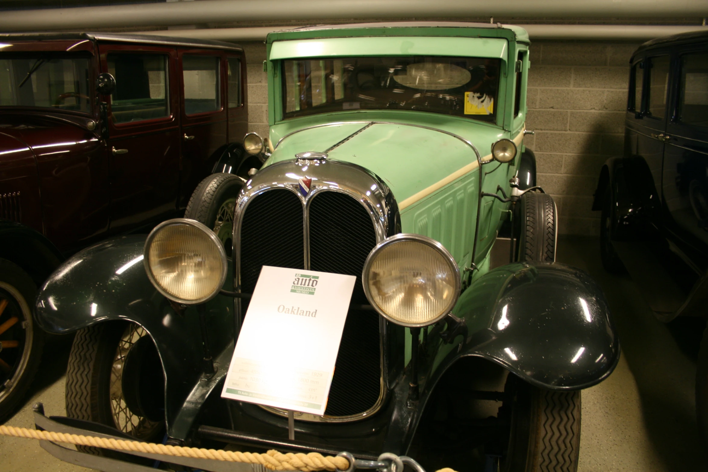 an old model car in a museum with its headlight turned