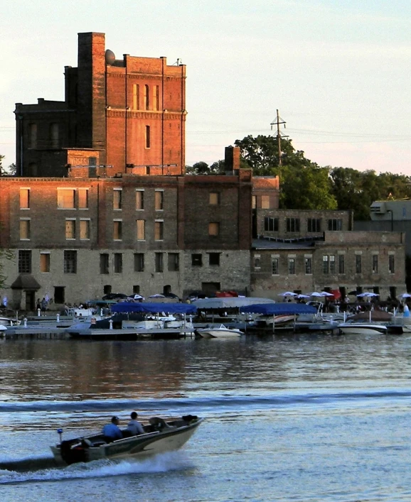 a row boat and people in a body of water near a building