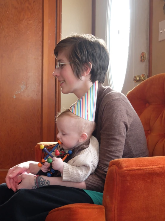 a woman holds a small child on her lap