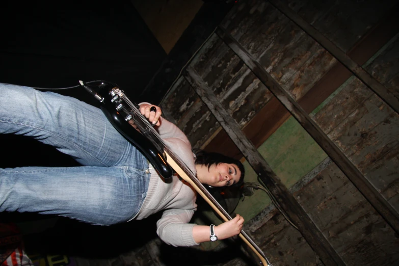 a young lady playing guitar in a bar or club